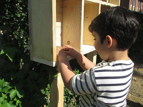 Ein Junge füllt das Insektenhotel