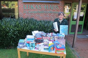 Heidi Schlichting mit Büchertisch vor dem Lukas-Haus