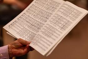 Chorprobe der Kantorei der Evangelischen Kirchengemeinde Frankfurt-Bornheim in der Johanniskirche. Der Blick richtet sich auf Noten, die in der Hand gehalten werden.