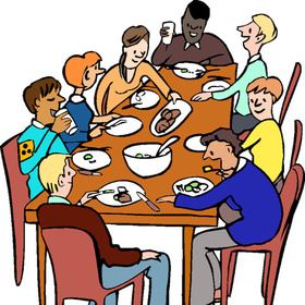 Acht Menschen sitzen an einem Tisch zusammen und essen Abend-Essen. Es ist eine diverse Gruppe. Sie scheinen sich angeregt zu unterhalten. Die Person vorne links trägt eine Blinden-Armbinde.