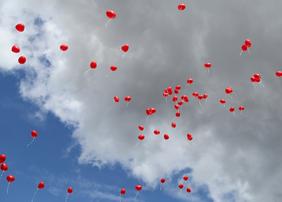 Rote Herzluftballons am blauen Himmel
